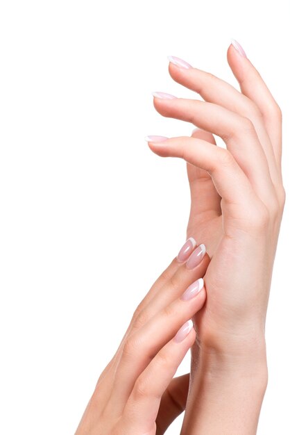Mani della bella donna con belle unghie dopo il salone di manicure con french manicure