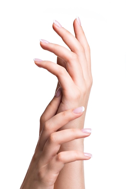 Mani della bella donna con belle unghie dopo il salone di manicure con french manicure