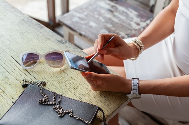 Mani di donna alla moda utilizzando smartphone