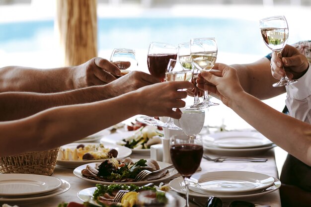 Mani di persone con bicchieri di champagne o di vino, celebrando e tostando in onore del matrimonio o di altre celebrazioni.