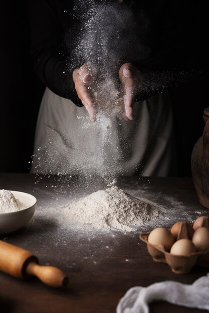 Mani di vista frontale che cucinano con il fiore