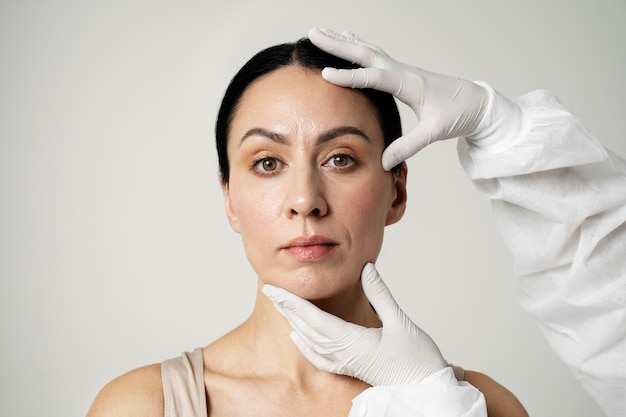 Mani di vista frontale che tengono la testa della donna