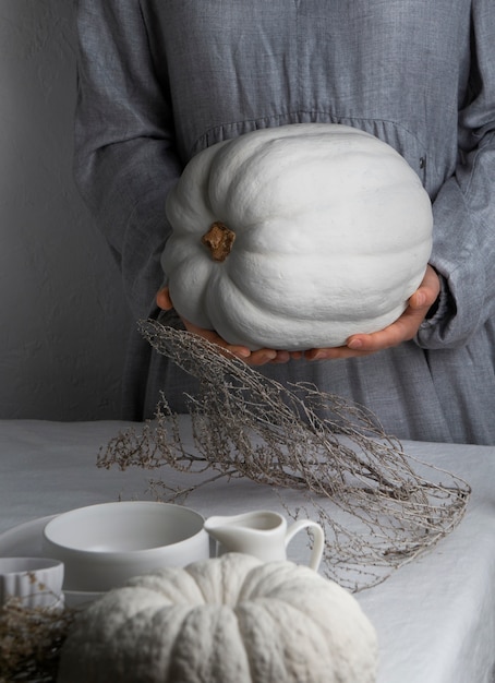 Mani di vista frontale che tengono la zucca bianca