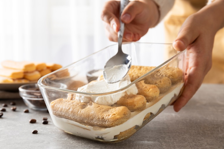 Foto gratuito mani di vista laterale che cucinano il tiramisù