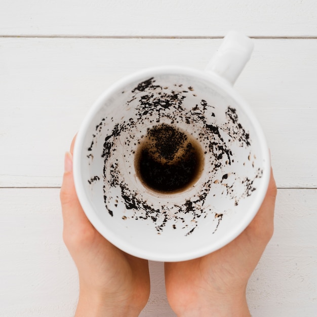 Mani di vista superiore che tengono tazza di caffè