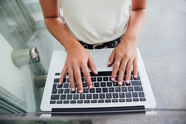 Mani di vista superiore sulla tastiera del computer portatile