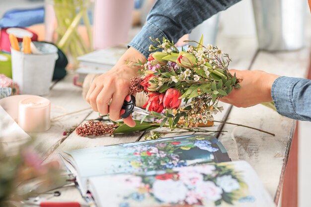 mani femminili che fanno il mazzo di fiori diversi