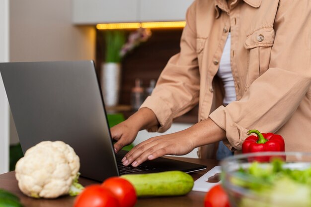 Mani femminili che lavorano al computer portatile in cucina