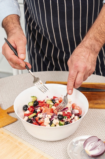 Mani maschii che mescolano un'insalata saporita