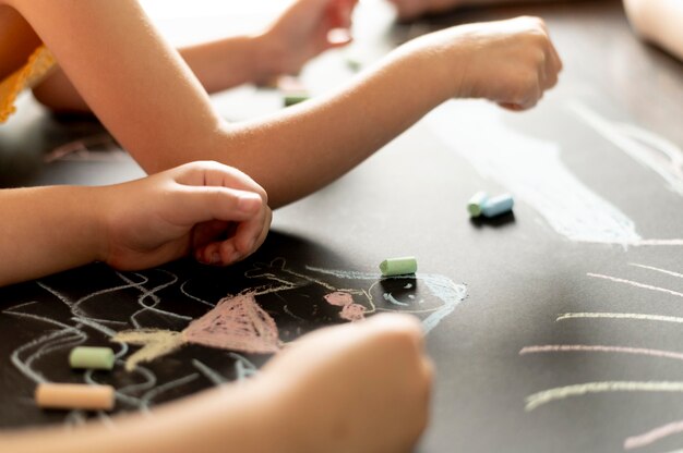 Mani ravvicinate che disegnano con il gesso