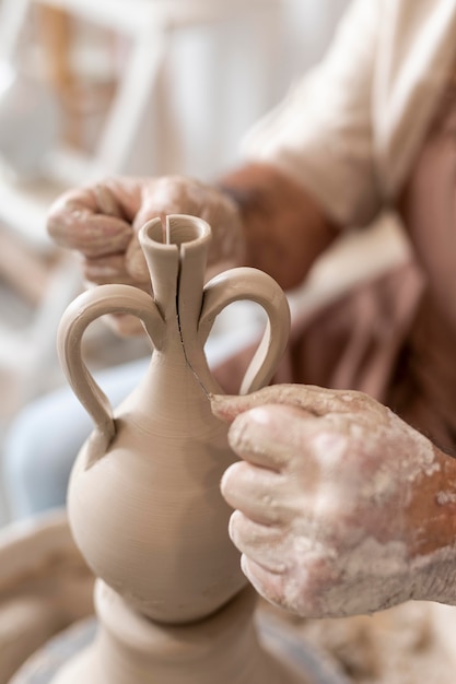 Mani ravvicinate che fanno il vaso di argilla