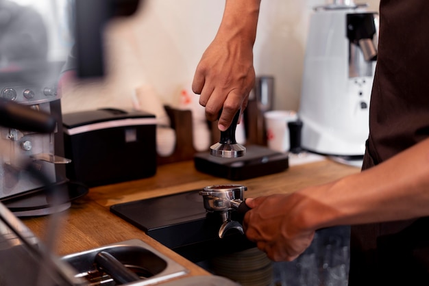 Mani ravvicinate che preparano il caffè