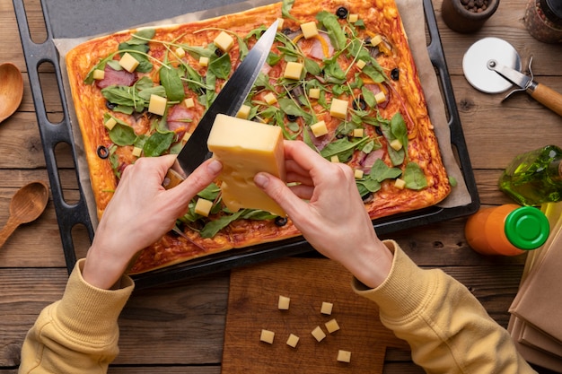 Mani ravvicinate che tagliano il formaggio