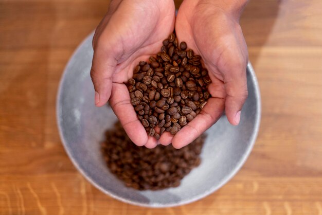 Mani ravvicinate che tengono i chicchi di caffè