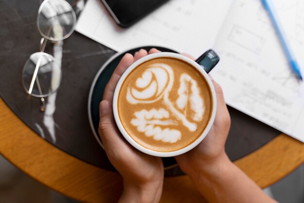 Mani ravvicinate che tengono la tazza di caffè