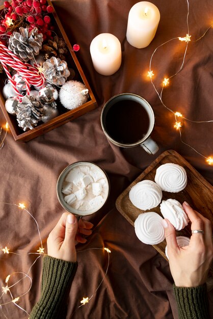 Mani ravvicinate che tengono tazza e biscotto