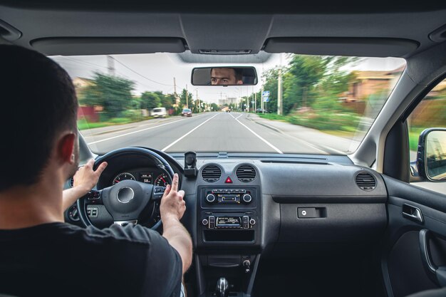 Mani sul volante durante la guida ad alta velocità dall'interno dell'auto