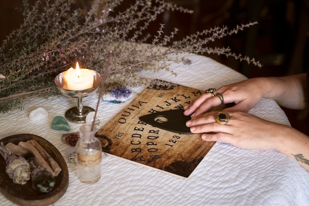 Mani usando la vecchia vista laterale della tavola di legno di Ouija