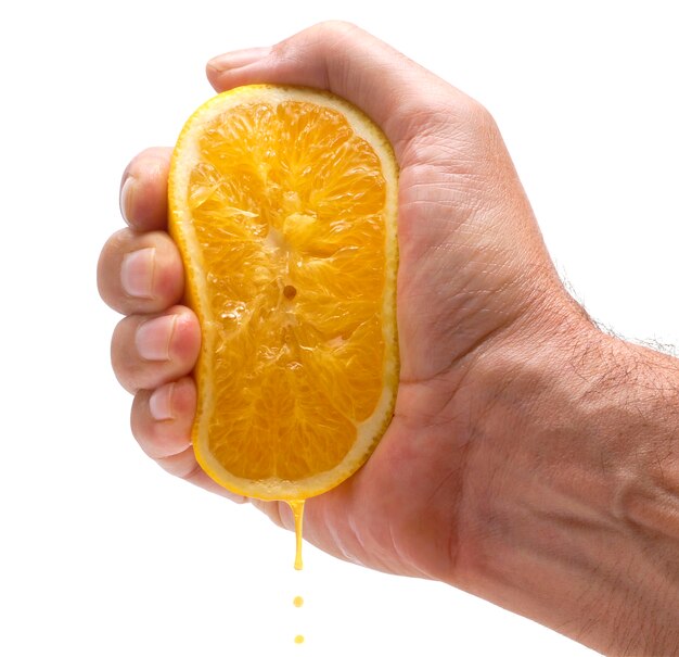 Mano che comprime il succo di arancia