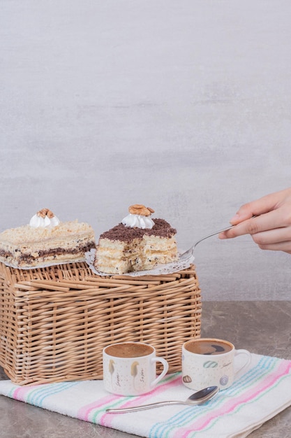 Mano che prende un pezzo di torta sulla tavola bianca.