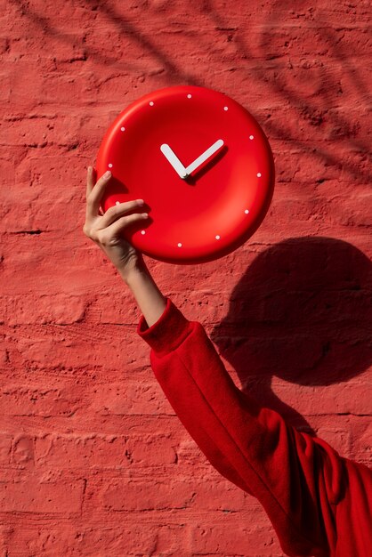 Mano che tiene l'orologio da parete ancora in vita