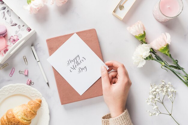 Mano che tiene la bella carta festa della mamma