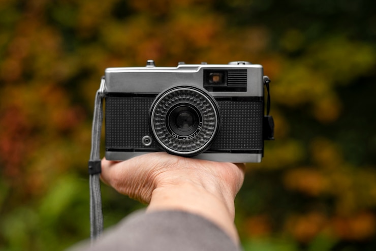 Foto gratuito mano che tiene la macchina fotografica