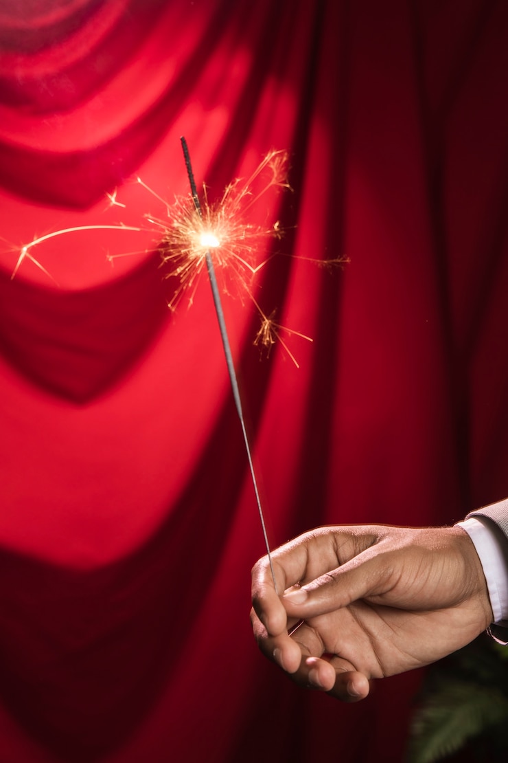 Foto gratuito mano che tiene un'esplosione di stelle filanti in fiamme