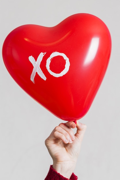 Mano che tiene un palloncino a cuore