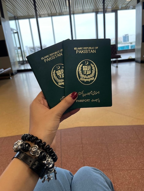 Mano da vicino che tiene il passaporto del Pakistan isolato su sfondo bianco