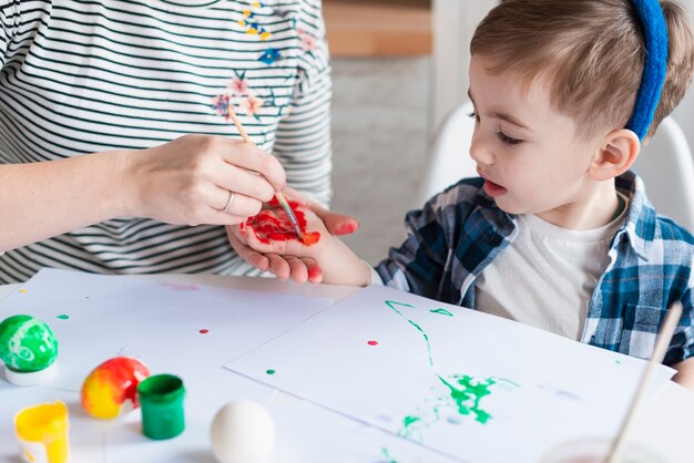 Mano dei ragazzini della pittura della madre del primo piano