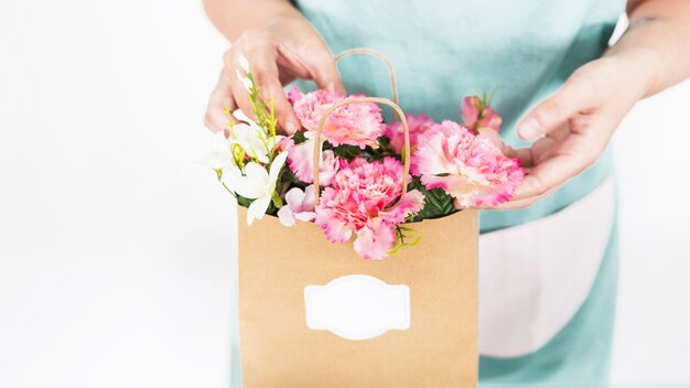 Mano del fiorista che tocca i fiori in sacco di carta