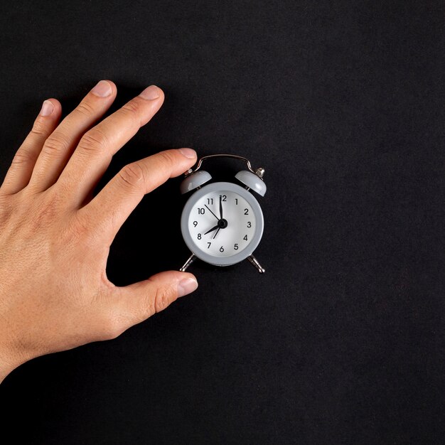 Mano del primo piano che organizza un orologio d'annata