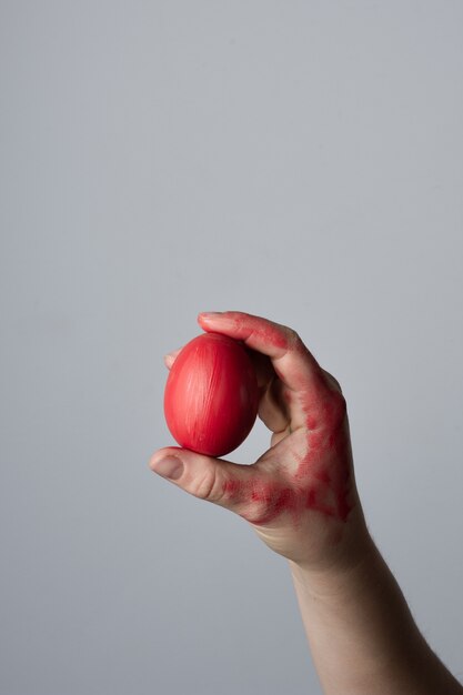 Mano del primo piano che tiene l'uovo di Pasqua tradizionale