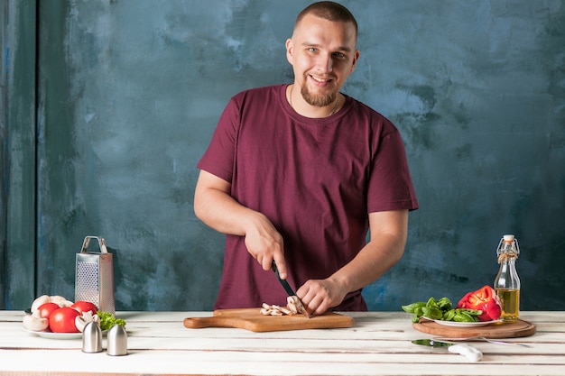 Mano del primo piano del panettiere del cuoco unico che produce pizza alla cucina