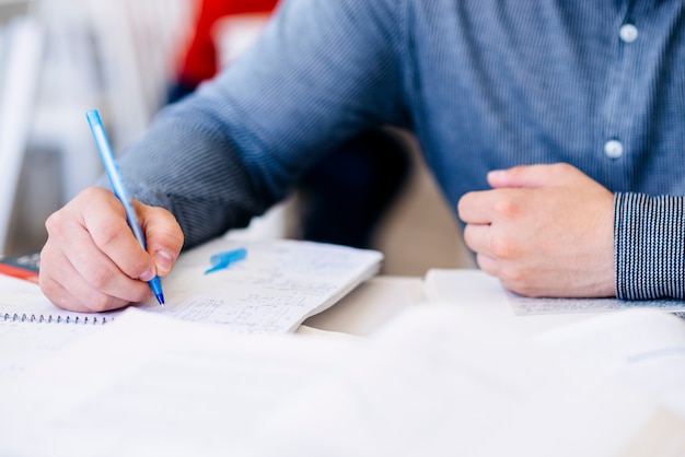 Mano dell&#39;uomo che scrive in taccuino