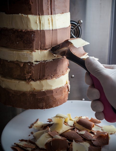 Mano dell'uomo di vista laterale che affetta cioccolato in bianco e nero