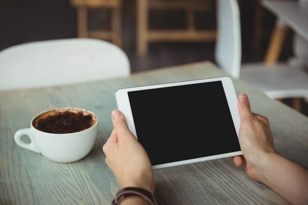 Mano della donna che per mezzo della compressa digitale