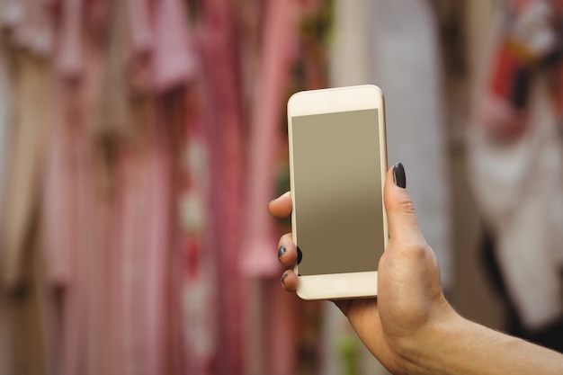 Mano della donna che tiene il telefono cellulare