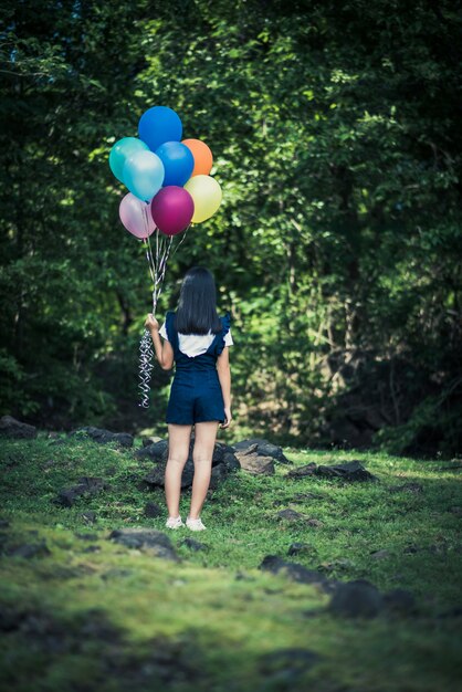 Mano della ragazza che tiene i palloni variopinti