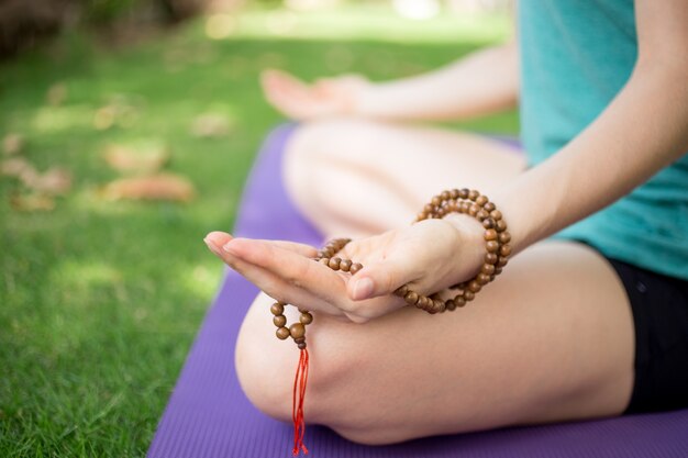 Mano di meditazione donna che tiene perline di rosario