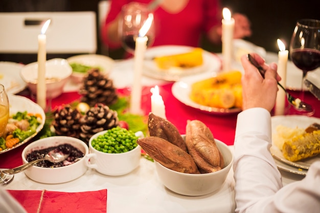 Mano di persona che mangia al tavolo festivo