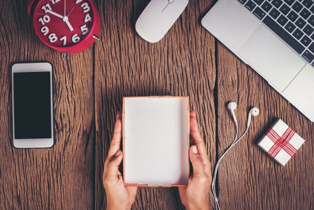 Mano di vista superiore che tiene scatola vuota sull&#39;area di lavoro