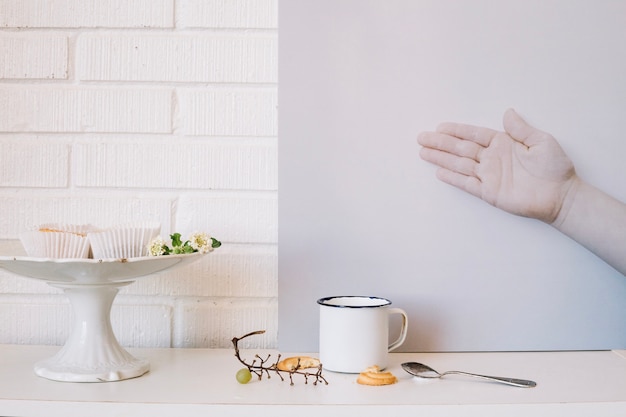 Mano e tazza con cibo mangiato