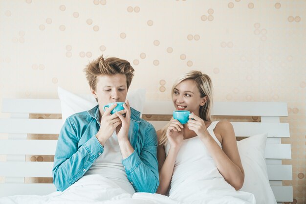 Mano felice delle coppie che tiene tazza e che beve caffè di mattina