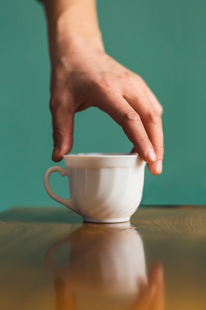 Mano prendendo tazza di ceramica