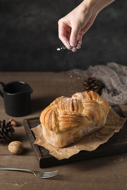 Mano spolverare di zucchero sulla torta fatta in casa