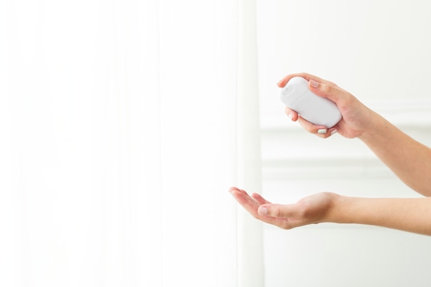 Mano utilizzando un disinfettante per le mani portatile