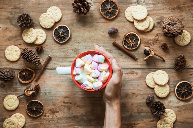 Mano vicino a cioccolata calda e spezie