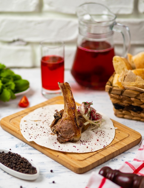 Manzo agnello chop pasto in lavash sul piatto di legno con pane, vegetabels e vino